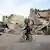 A boy cycling past a bombed out building in Eastern Ghouta