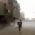Man running through the dust in Eastern Ghouta