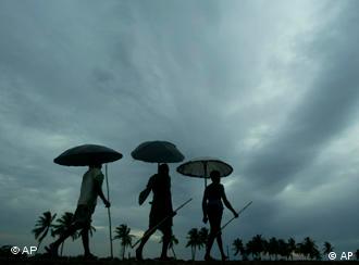 Habitantes de Bhubaneswar, en la India, se protegen de la lluvia tras el paso del ciclón Aila.