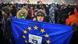 A protester in Bucharest on February 25 holds up an EU flag with the words, 'Anticorruption is in my DNA.' A protester in Bucharest on February 25 holds up an EU flag with the words, 'Anticorruption is in my DNA.'