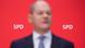 A blurry Olaf Scholz in front of a red SPD sign A blurry Olaf Scholz in front of a red SPD sign
