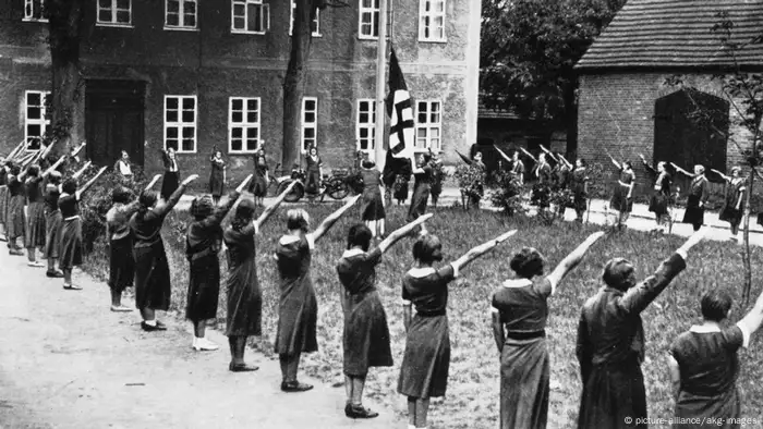 Women during the Nazi era stretching out their hands.