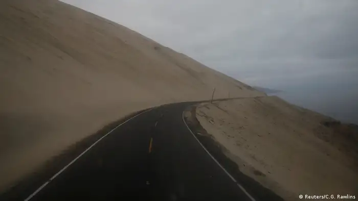 La carretera serpentea junto al mar en Atico, Perú, el 13 de noviembre de 2017, mientras Carlos García Rawlins disfruta de la vista desde la primera fila en el piso superior del autobús. Dijo sentir a veces un sentimiento de vacío mientras el camino desaparecía detrás de una curva y la niebla descendía, cubriendo el horizonte.