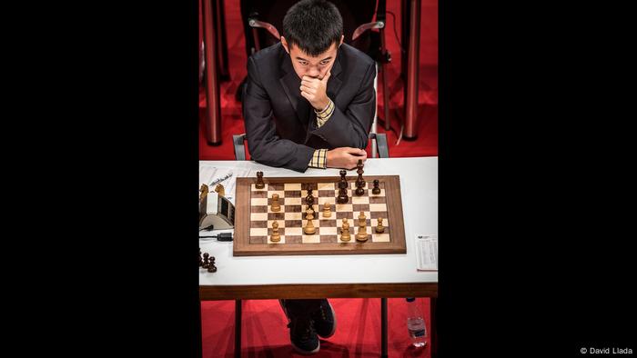 Ding Liren sitzt vor einem Schachbrett (Foto: David Llada)