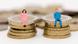 A man and a woman sitting on stacked coins A man and a woman sitting on stacked coins