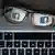 Über einer Tastatur liegt eine Brille, in deren Gläsern sich das Facebook-Logo spiegelt