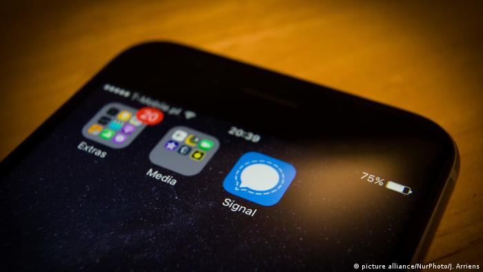 A smartphone screen shows the icon of the messaging app Signal 