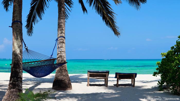 tropischer Strand mit Palmen, Liegestühlen und Hängematte, tropical beach with palm trees, hammock and canvas chairs