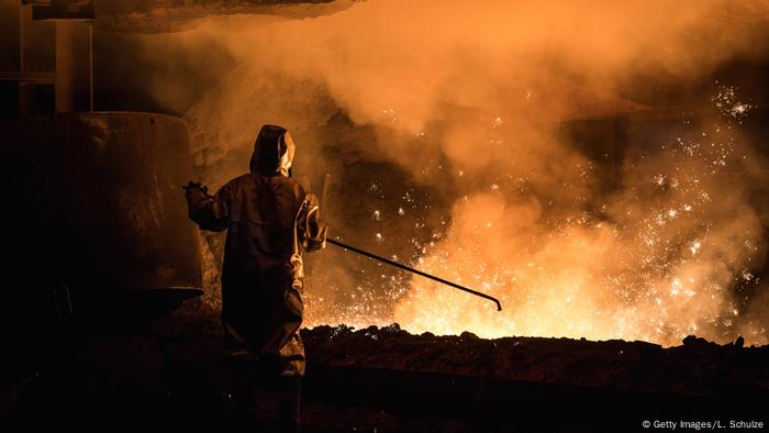 A worker oversees molten iron undergoing purification and alloying to become steel in Duisburg