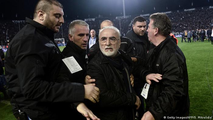 PAOK Thessaloniki owner Ivan Savvidis had to be held back by his own security team after storming the pitch against AEK Athens