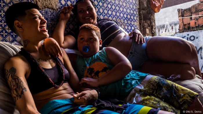 Three people lying next to each other in a run-down building in Rio (DW/S. Derks)