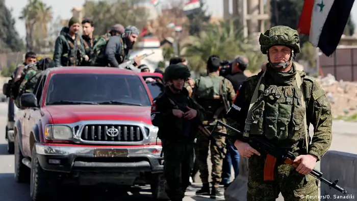 Russian soldiers are seen guard at a checkpoint near Wafideen camp in Damascus