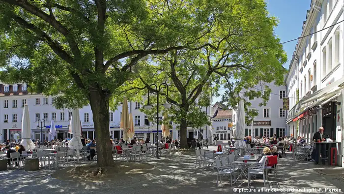 People sitting under a tree in a square
