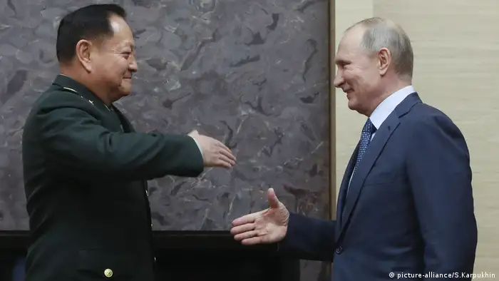 Der russische Präsident Wladimir Putin schüttelt dem stellvertretenden Vorsitzenden der Zentralen Militärkommission Zhang Youxia die Hand (picture-alliance/S.Karpukhin)