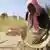 A poor farmer sifts grain in Nigeria