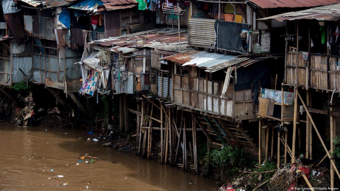 Viviendas precarias sobre pilotes junto a un canal en Yakarta.