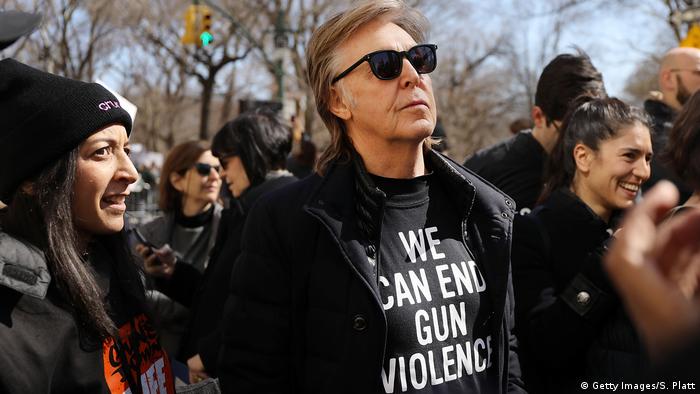 Paul McCartney wears an anti-gun violence T-shirt and sunglasses while marching in a protest