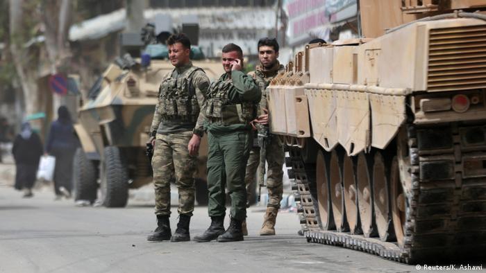 Turkish soldiers are seen standing next to a tank in the center of Afrin, Syria.