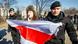 Police arrest a protester carrying the red and white flag of the Belarusian People's Republic. Police arrest a protester carrying the red and white flag of the Belarusian People's Republic.