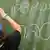 Pupil wearing a yarmulke writes on a blackboard