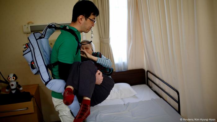 Ein Roboter-Muskel-Anzug unterstützt eine Pfleger in Japan beim Heben einer Seniorin. (Foto: Reuters)