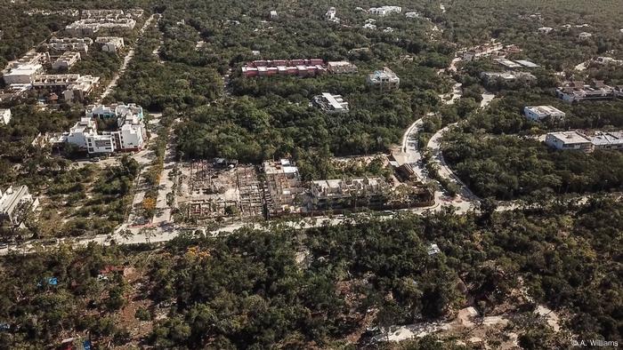 Blick aus der Luft auf Häuser und Straßen, die den Regenwald bei Tulum durchziehen