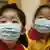 Students wearing mask listen to teacher at a pre-school facility