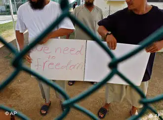 资料图片：被关押在关塔纳摩监狱的维吾尔人手持自制的标语发出要自由的呼吁(摄于2009年6月1日)