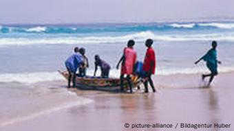 Fischer mit Boot am Strand im Senegal