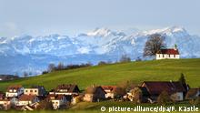 ***Archivbild*** 04.04.2018, Baden-Württemberg, Amtzell: Die Morgensonne strahlt die Heilig-Kreuz-Kapelle auf dem Kapellenberg an, während im Hintergrund der Berg Säntis in der Schweiz zu sehen ist. Foto: Felix Kästle/dpa +++(c) dpa - Bildfunk+++ | Verwendung weltweit
