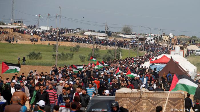 A long, broad, line of Palestinian protesters snakes through a tent city along the Israeli-Gaza border.
