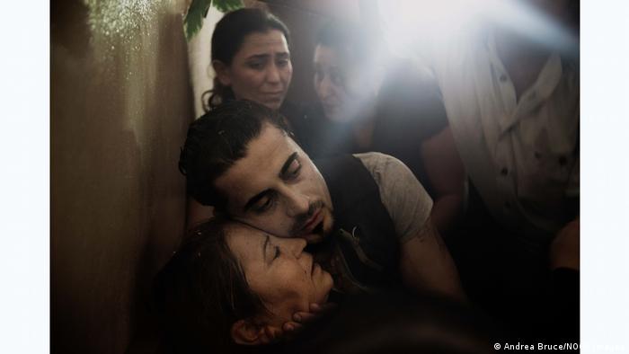 A Syrian mother is being hugged after finding out her son was killed. Andrea Bruce in Syria 2013