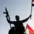 A Syrian soldier waves a flag during a protest against airstrikes in Damascus, Syria 