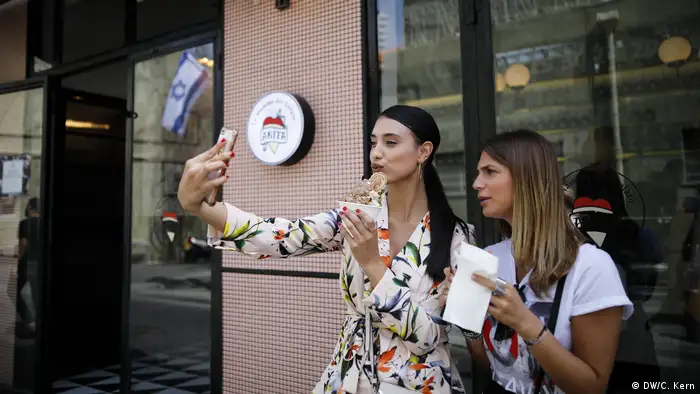 Girls take selfies in Shabazi street in Neve Tzedek, Israel