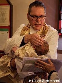 Rev. Christopher Eatshill tauft ein Baby. Wiesbaden Anglikanische Gemeinschaft