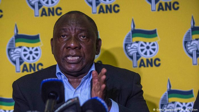 South African President Cyril Ramaphosa speaks to the media. The ANC party logo is in the background