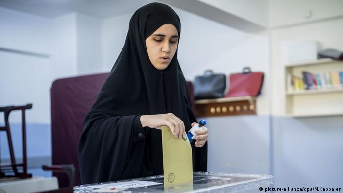 woman wearing a chador at the ballot box (picture-alliance/dpa/M.Kappeler)
