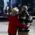 An elderly couple embraces as they look on to the scene of Toronto vehicle rampage