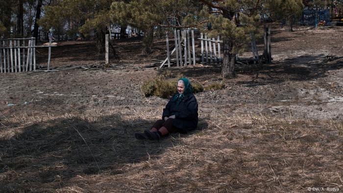 Baba Marusia sitting nearby the graveyards of Kupovate, a village in the exclusive zone of Chernobyl