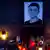 Poster of Jan Kuciak surrounded by lit candles