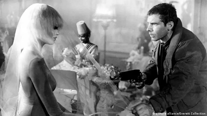 Rick Deckard (Harrison Ford) richtet in Blade Runner auf eine Replikantin. (picture alliance/Everett Collection)