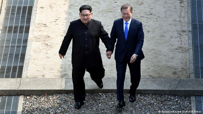 Kim and Moon walking hand-in-hand