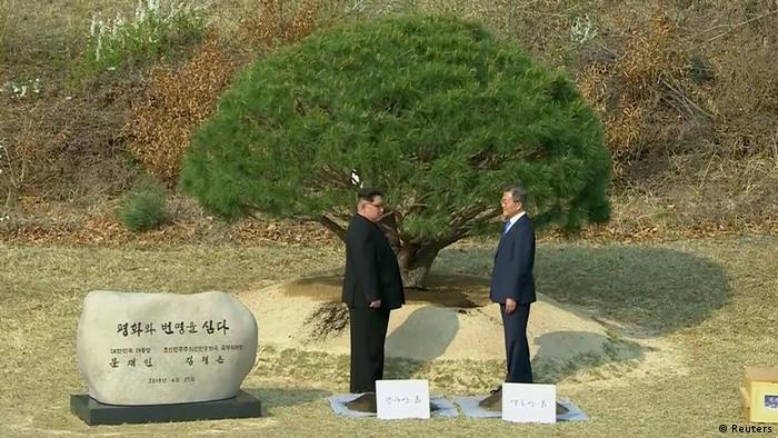 Kim Jong Un and Moon Jae-in face each other during a tree-planting ceremony