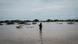 A woman walks through floodwaters in north-east Kenya A woman walks through floodwaters in north-east Kenya