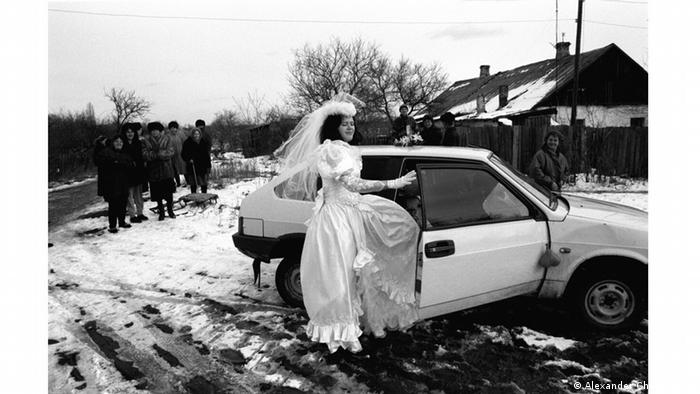 Schwarzweiß-Foto zeigt eine Braut, die ins Auto steigt (Alexander Chekmenev )