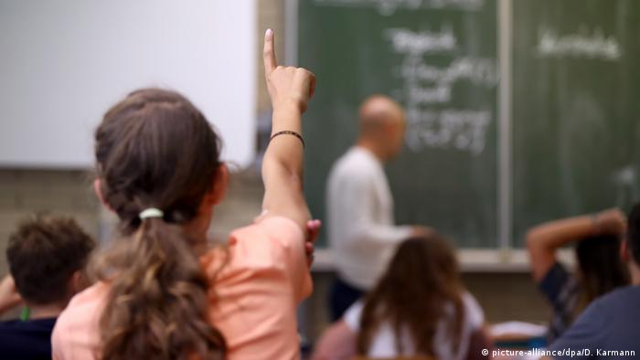 A schoolgirl raises a finger to ask a question during a class in Bavaria