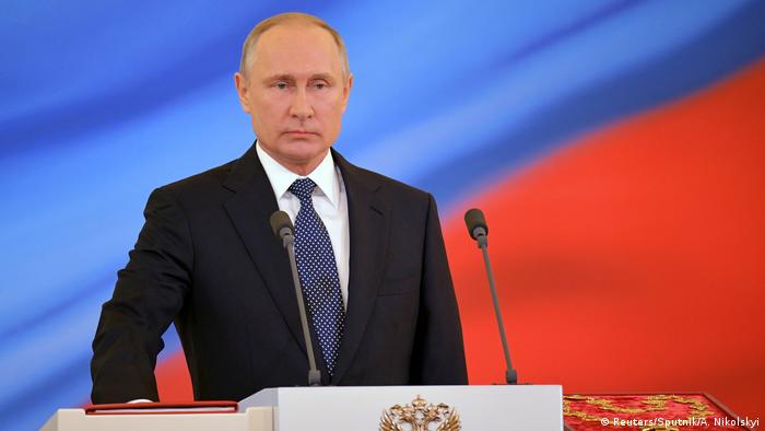 Russian President Vladimir Putin gives cash to police, soldiers ahead of polls