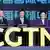 Members of the Chinese Communist party sit behind a desk bearing the CGTN logo