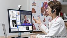 Symbolfoto zur Telemedizin Ärztin in einer Praxis kommuniziert mit dem Patienten über eine Webcam