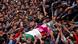 People touch the body of a suspected militant during his funeral procession in May of 2018 People touch the body of a suspected militant during his funeral procession in May of 2018